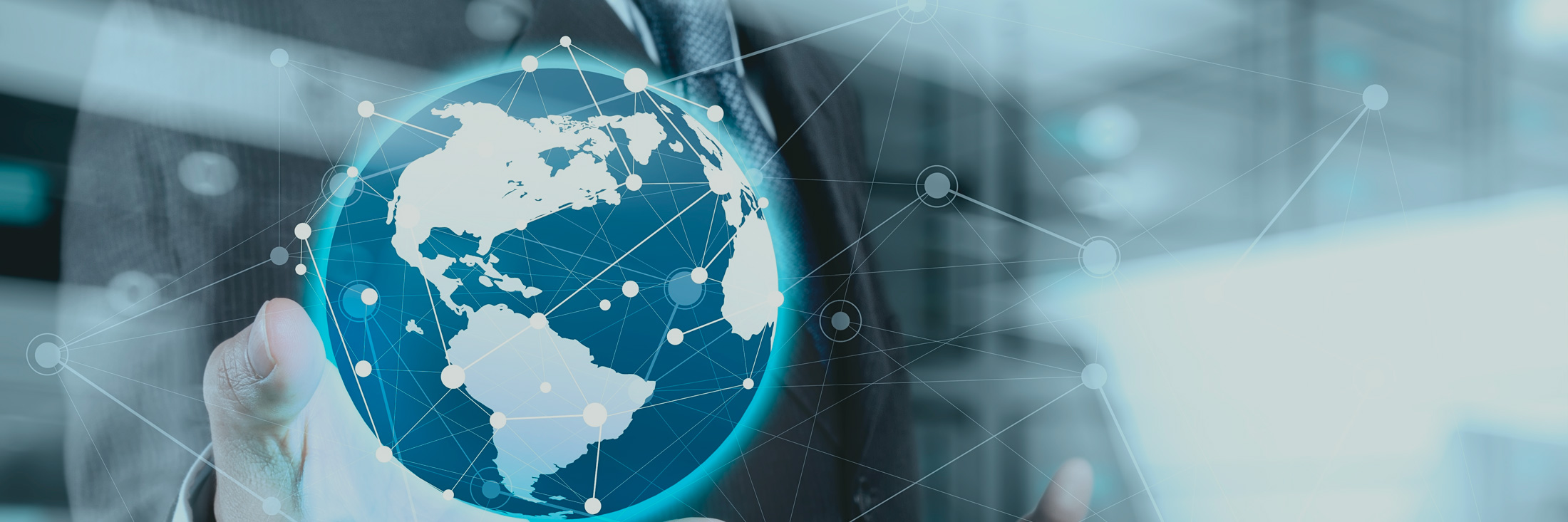 A businessman holding a holographic globe with digital connections representing global networking and technology.